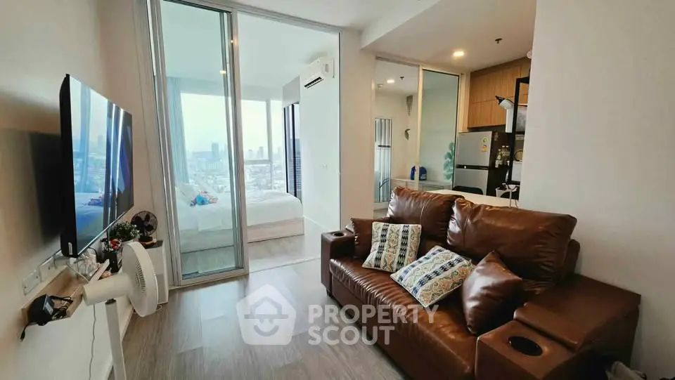 Modern apartment with cozy living room and bedroom view, featuring sleek furniture and cityscape backdrop.