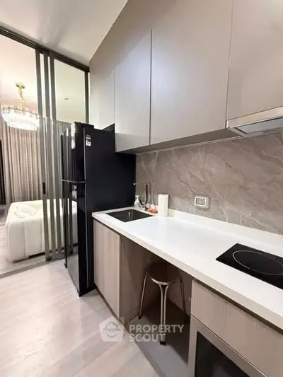 Modern kitchen with sleek cabinetry and induction cooktop in stylish apartment