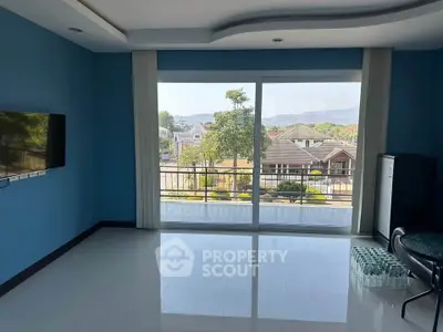 Spacious room with large windows offering scenic view of suburban neighborhood.