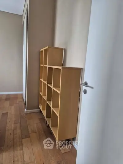 Spacious room with wooden flooring and modern shelving unit