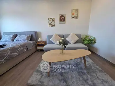 Cozy bedroom with stylish decor, featuring a plush bed, modern sofa, and elegant coffee table on a soft rug.