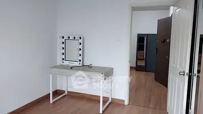 Spacious bedroom with modern vanity and wooden flooring