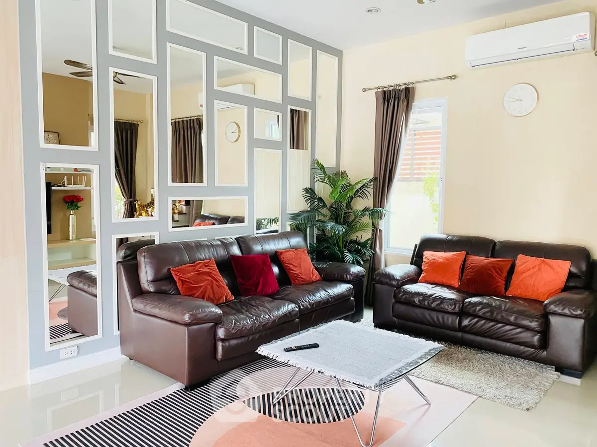 Stylish living room with modern decor, leather sofas, and unique wall mirror design.