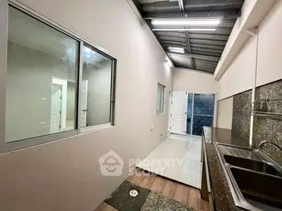 Spacious kitchen with modern sink and ample counter space, featuring a sleek open layout and natural lighting.