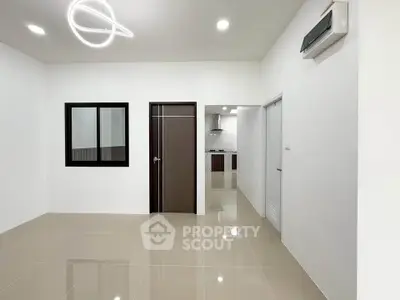 Modern minimalist living space with sleek lighting and glossy tiled floors.