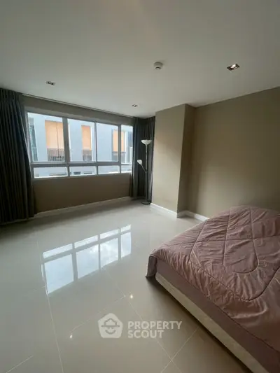 Spacious bedroom with large windows and modern decor