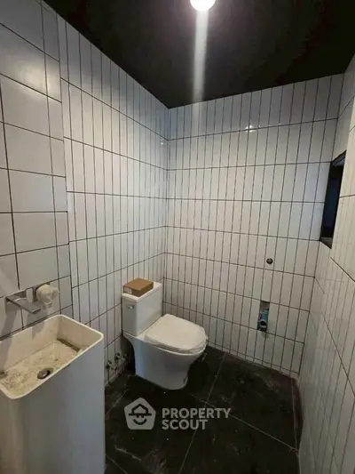 Modern bathroom with sleek white tiles and contemporary fixtures.
