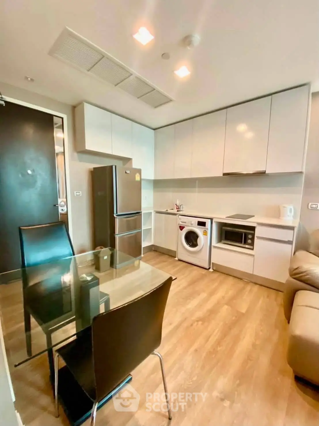 Modern kitchen with sleek appliances and dining area in stylish apartment
