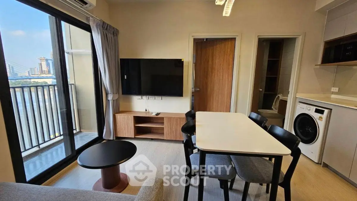 Modern living room with balcony, dining area, and in-unit laundry in urban apartment.