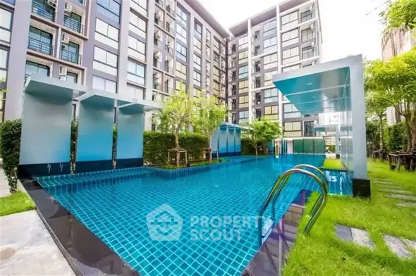 Luxurious modern apartment complex with stunning outdoor pool and lush greenery.