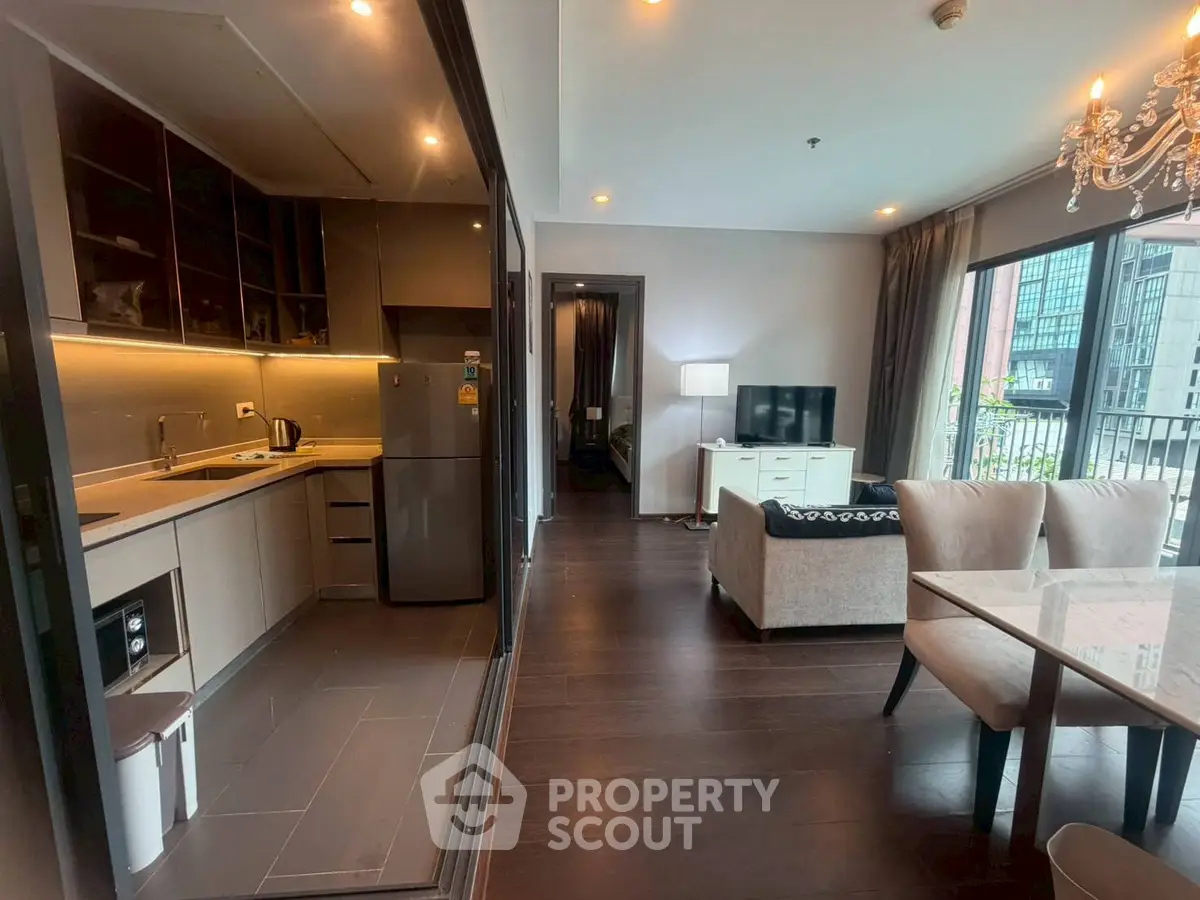 Modern open-layout living room and kitchen with elegant dining area and large windows.