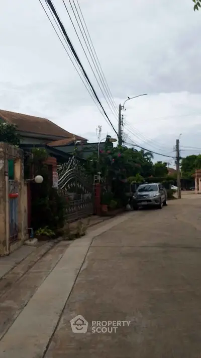 Charming suburban street view with lush greenery and residential homes.