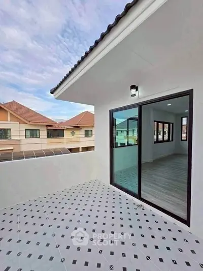 Spacious balcony with modern tiles and sliding glass doors in a suburban home.