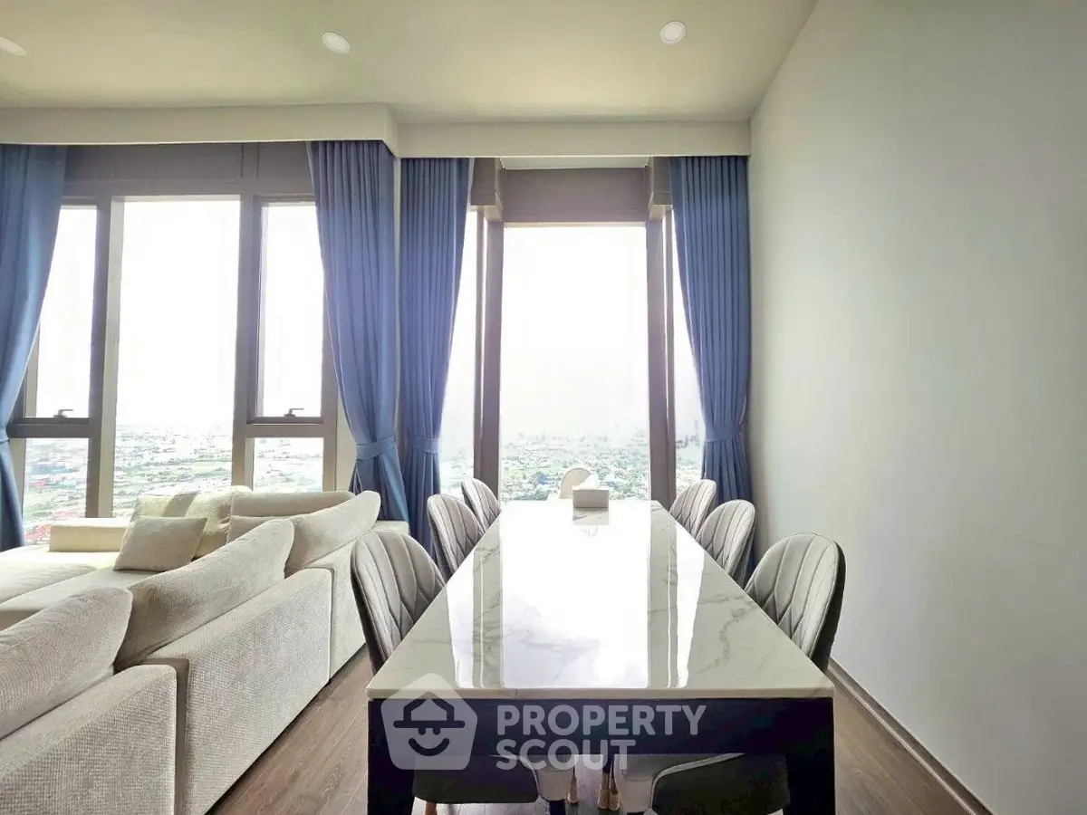 Elegant living room with panoramic windows and stylish dining area in modern apartment.