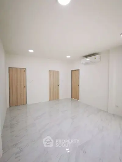 Spacious modern room with marble flooring and air conditioning, ideal for versatile living space.