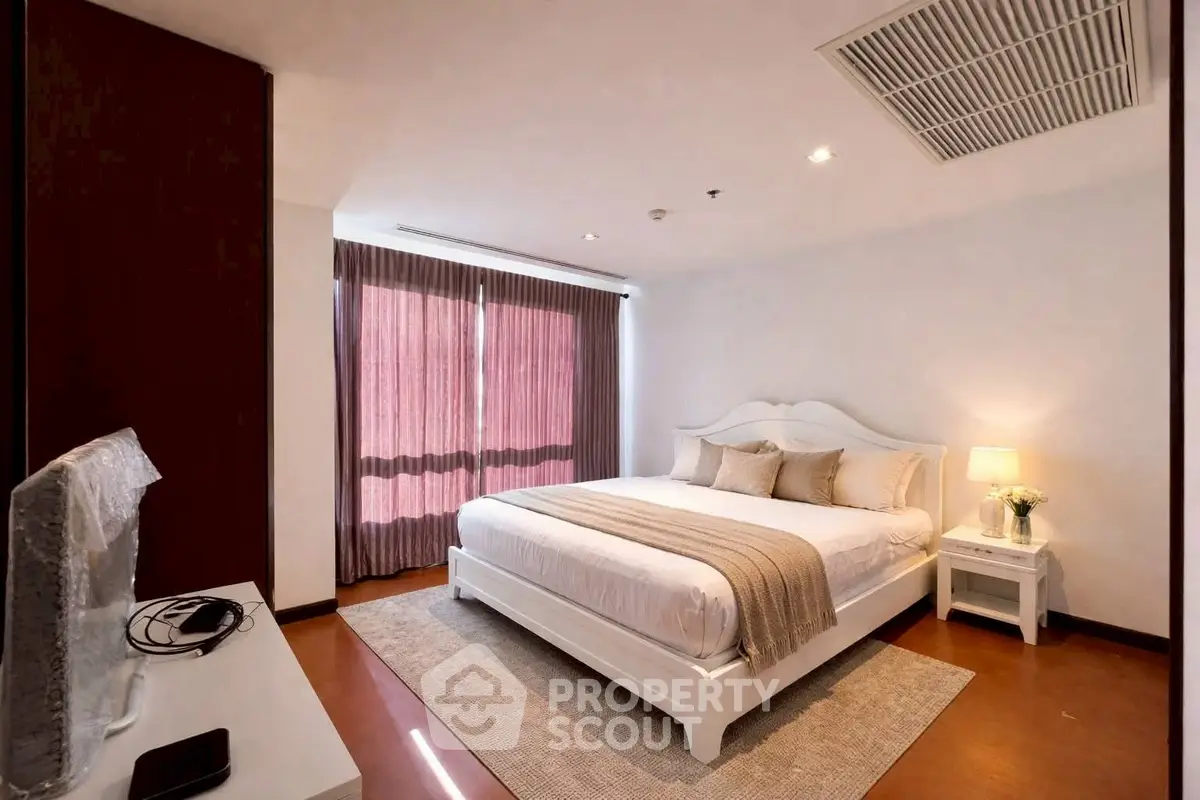 Elegant bedroom with cozy decor and natural light, featuring a plush bed and stylish furnishings.