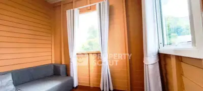 Cozy wooden interior with natural light and modern sofa, perfect for relaxation.