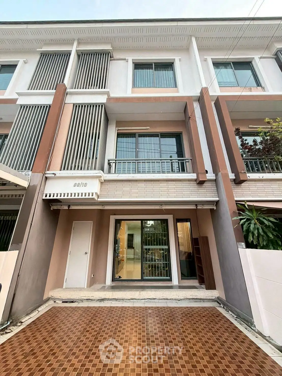 Modern townhouse exterior with tiled driveway and large windows