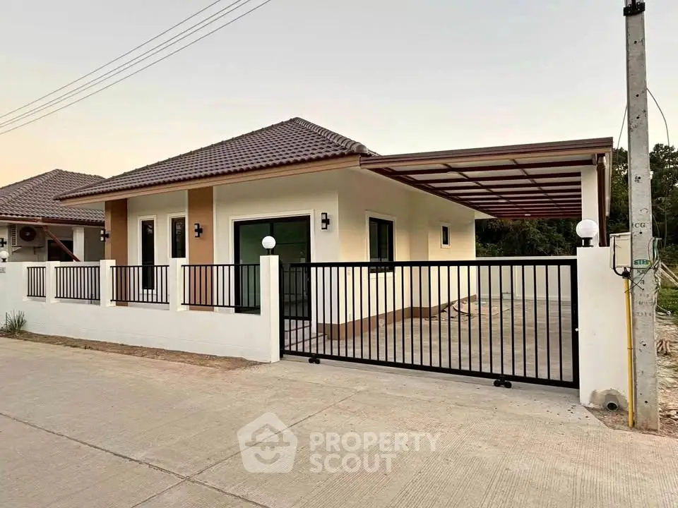 Modern single-story house with gated driveway and stylish exterior design.