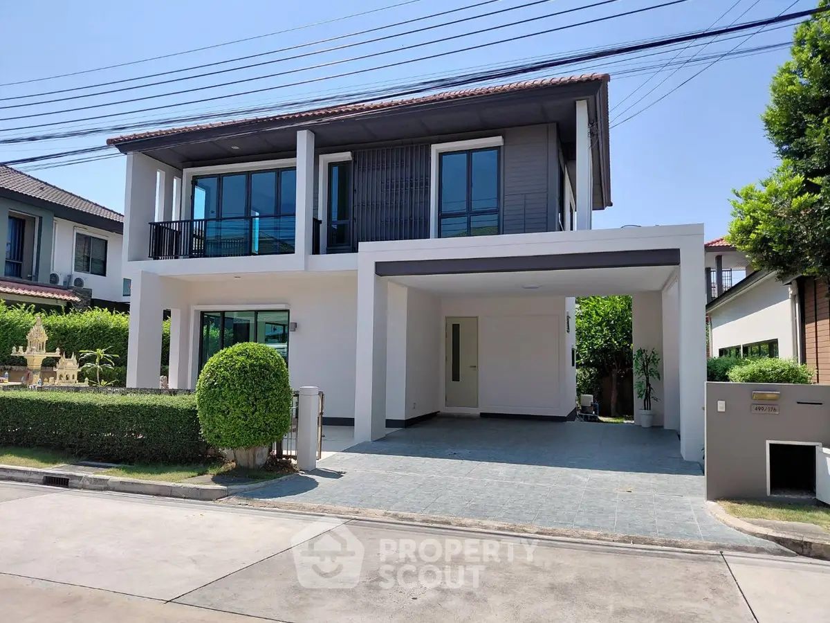 Modern two-story house with spacious driveway and manicured garden in a serene neighborhood.