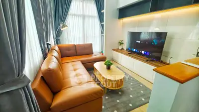 Stylish modern living room with leather sofa and large TV, perfect for relaxation and entertainment.