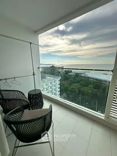 Stunning balcony with panoramic city view and modern seating area.