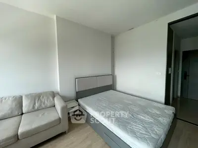 Modern bedroom with cozy sofa and minimalist design, perfect for urban living.
