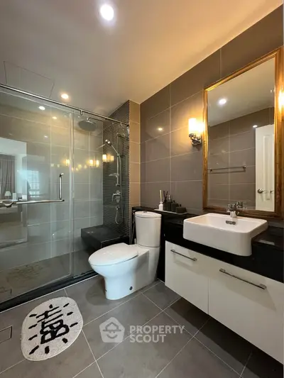 Modern bathroom with glass shower, sleek fixtures, and elegant lighting