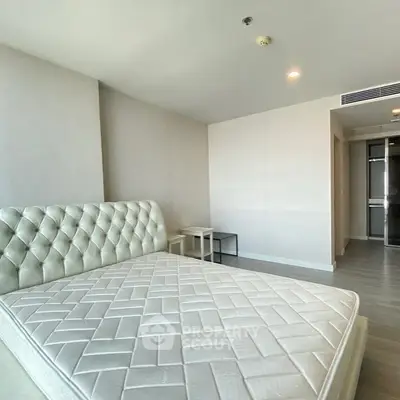 Spacious bedroom with elegant tufted headboard and modern decor