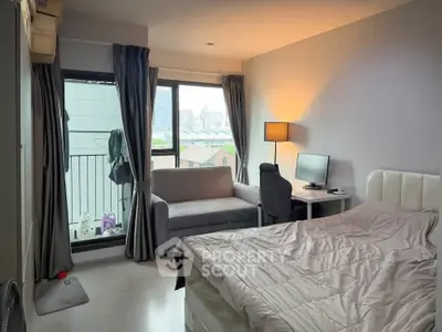 Cozy bedroom with city view, featuring a comfortable bed, sofa, and workspace, ideal for urban living.