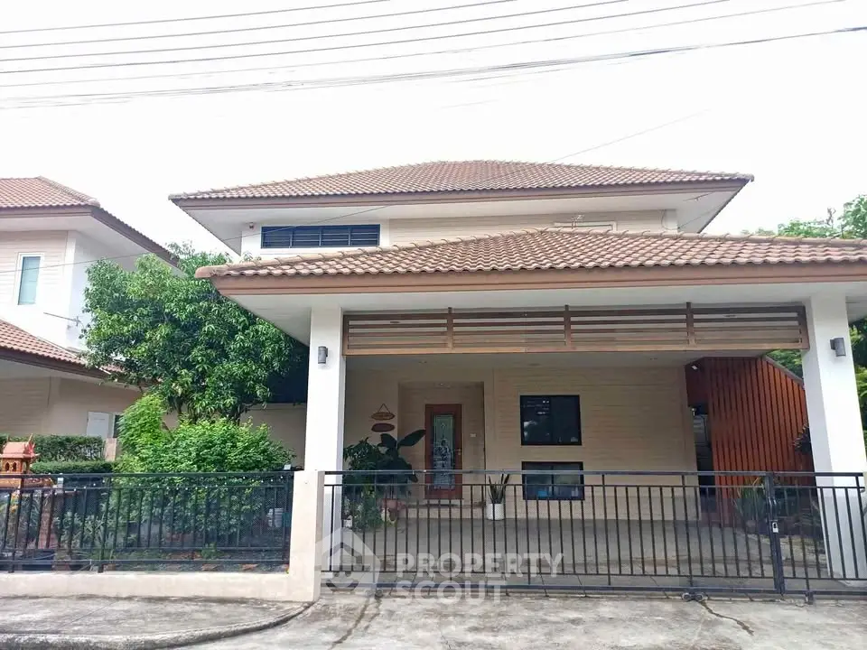 Charming two-story house with tiled roof and spacious driveway in a serene neighborhood.
