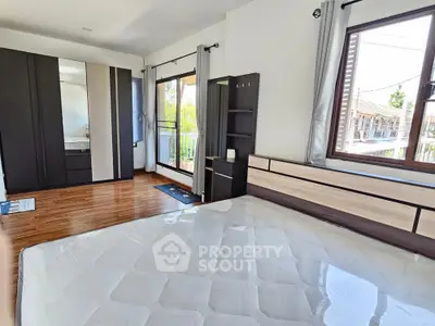 Spacious bedroom with large windows and modern wardrobe in a bright home.