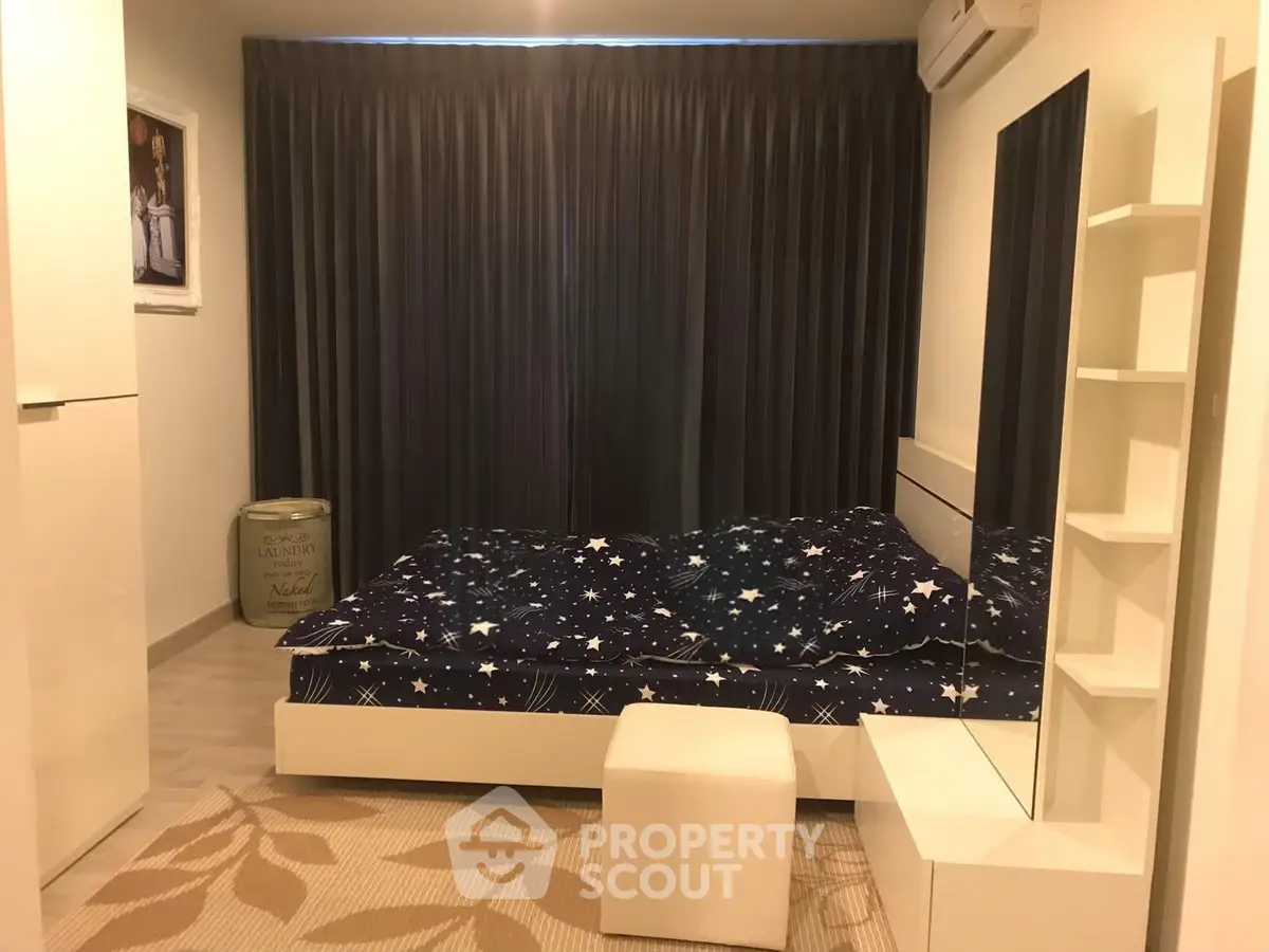 Cozy bedroom with starry bedding, modern decor, and ample storage space.