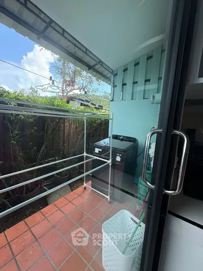 Charming small balcony with tiled flooring and laundry area, perfect for urban living.