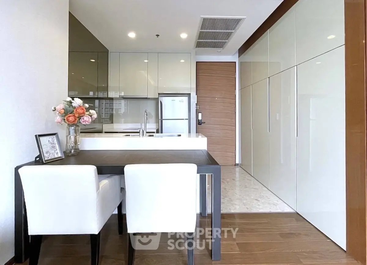Modern kitchen with sleek cabinetry and dining area in luxury apartment