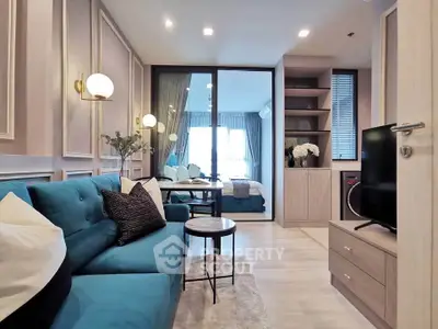 Modern living room with stylish decor and open view to bedroom, featuring elegant lighting and cozy seating.