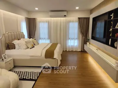 Luxurious bedroom with elegant decor and modern furnishings, featuring a cozy bed and stylish entertainment unit.