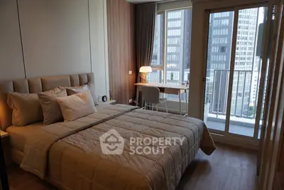 Modern bedroom with city view and balcony access in high-rise apartment.