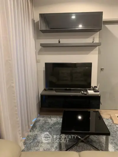 Modern living room with sleek TV setup and stylish shelving, perfect for cozy entertainment nights.