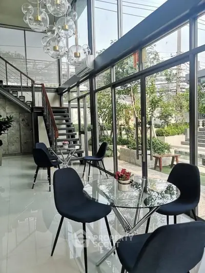 Stunning modern living area with floor-to-ceiling windows and elegant glass decor.