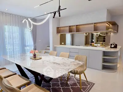 Luxurious dining area with elegant marble table and modern lighting in open-concept kitchen.