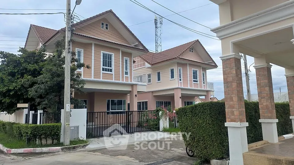Charming suburban house with pink exterior and lush greenery, perfect for family living.
