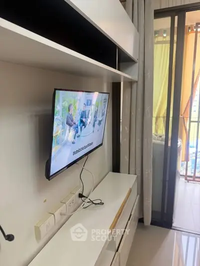 Modern living room with wall-mounted TV and balcony view