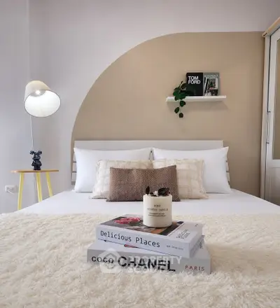 Stylish bedroom with modern decor and cozy ambiance, featuring designer books and elegant lighting.