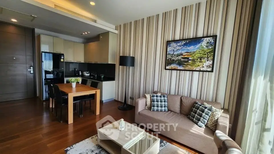 Modern living room with stylish decor and open kitchen layout, featuring a cozy sofa and dining area.