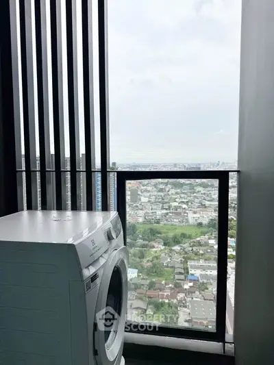 High-rise balcony with washing machine and stunning city view.