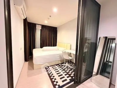 Modern bedroom with stylish decor, featuring a cozy bed, sleek desk, and elegant curtains in a well-lit space.