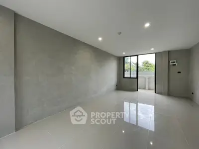 Spacious modern living room with large window and sleek tile flooring