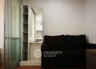 Modern living room with sleek black sofa and mirrored storage unit