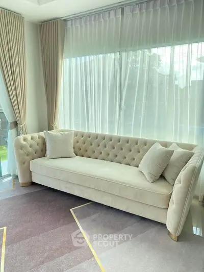 Elegant living room with plush beige sofa and large windows